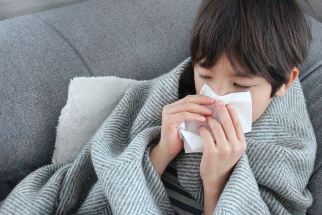 風邪症状で鼻をかむ子ども