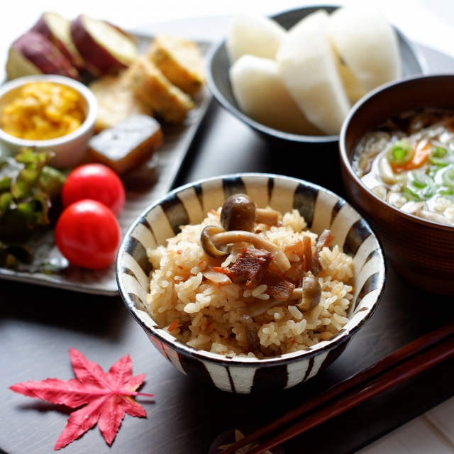秋の和食献立（炊き込みご飯、煮物、味噌汁、小鉢）が並んだ健康的な食卓の写真