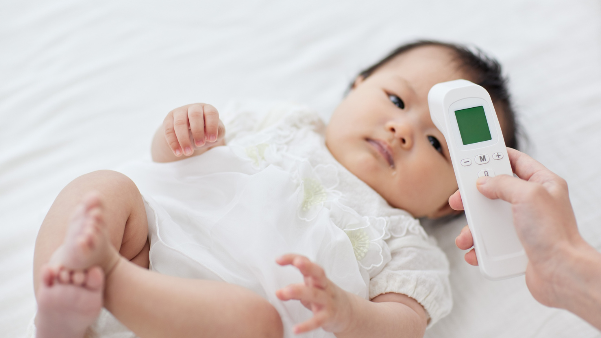 赤ちゃんの体温を非接触体温計で測る写真