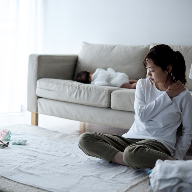 朝から体がだるく、疲れを感じているママの様子。休んでも疲れが取れない状態を表すイメージ。